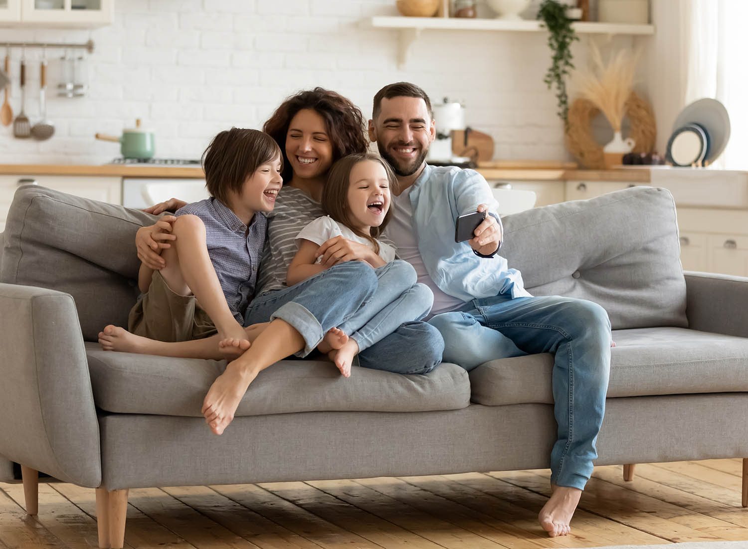 Mutual Savings Credit Union Membership family sitting on sofa laughing